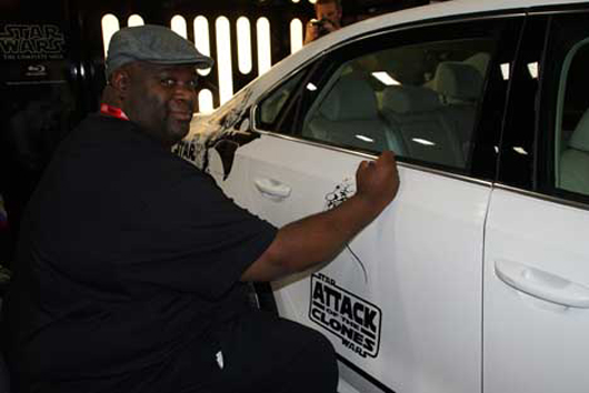 Continuing the cooperation seen in the popular Super Bowl commercial with the little Darth Vader, artist Ken Lashley was in the convention hall’s Star Wars pavilion, working on illustrating the outside of a Volkswagen Passat in ‘Star Wars: Attack of the Clones’ livery. Photo by Michael A. Solof.